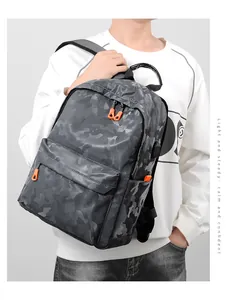 Détail du sac à dos camouflage avec fermeture éclair orange et port de chargement USB intégré