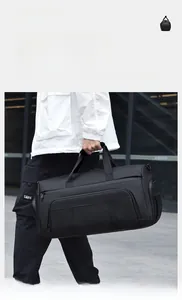Mann trägt eine große schwarze wasserdichte Reisetasche mit mehreren Reißverschlussfächern