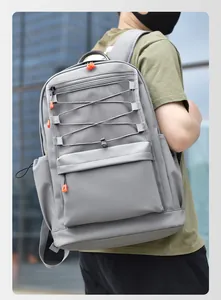 Detail of gray backpack featuring orange zippers and mesh compartments for urban commuting