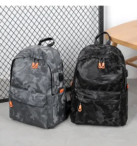 Détail du sac à dos camouflage avec fermetures orange et port de chargement USB externe