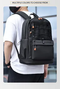 Detailed outdoor shot of black multi-pocket backpack with vibrant orange zipper pulls