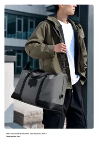 Detail view of large grey travel bag with padded shoulder strap and modern urban finish