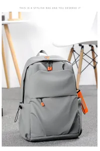 Detail of grey laptop backpack with orange fashion zipper pulls in a modern room