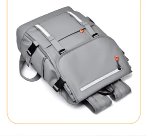 Detail view of grey backpack with white reflective strips and orange zipper pulls