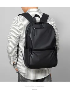 Rear view of model wearing a matte black laptop backpack with wide padded shoulder straps