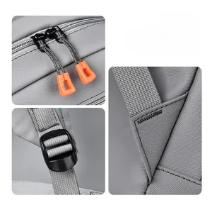 Detail of durable dual metal zippers with orange pulls and reinforced stitching on gray backpack