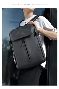Outdoor shot of a black waterproof business backpack with modern matte finish on a model