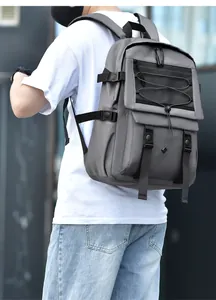 Detail of grey outdoor backpack showing mesh pocket and adjustable compression straps