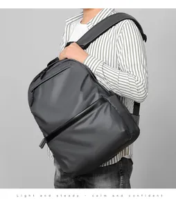Detail view of water-resistant gray business backpack with padded straps and sleek leather trim