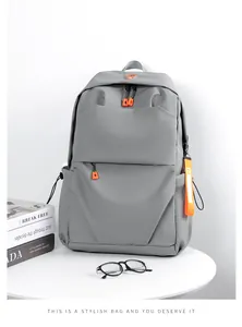 Close-up of minimalist grey backpack with vibrant orange zippers and fabric texture details