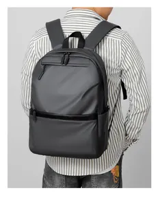 Rear view of model wearing a minimalist deep gray waterproof 15 inch laptop backpack