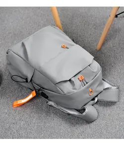 Detail view of grey backpack showing USB charging port and breathable mesh padding