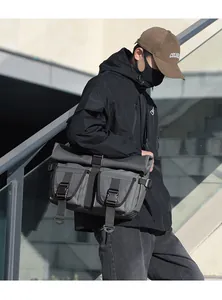 Detail of dark grey techwear messenger bag featuring dual buckle pockets and waterproof fabric
