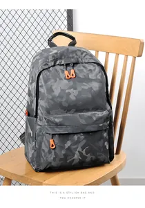 Détail d'un sac à dos camouflage gris avec tirettes orange sur une chaise en bois