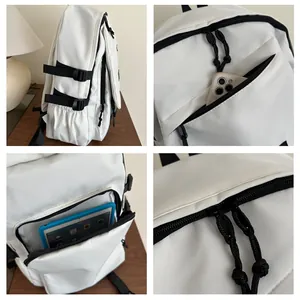 Detail view of white backpack showing side buckles, interior pockets and tablet storage