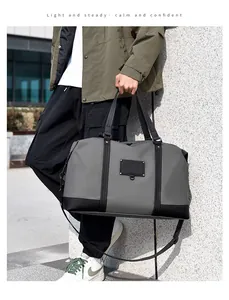Close-up of a large gray and black travel bag with a waterproof finish and strap