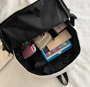 Top view of white backpack interior showing large capacity for tablets and notebooks