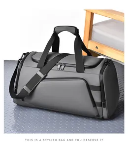 Detail view of large gray fitness bag showing waterproof fabric and durable black zippers