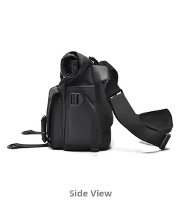 Side view of waterproof black crossbody bag showing roll-top closure and padded strap