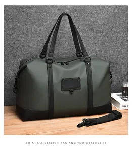 Detail of dark green waterproof travel bag with leather handles and matte coating