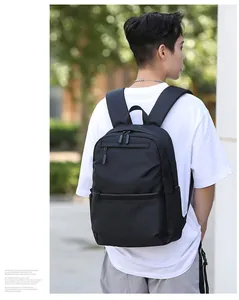 Rear view of black waterproof backpack with multiple compartments on a male model