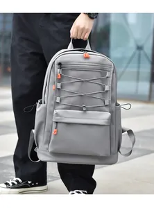 Detail of grey nylon backpack with mesh pocket, orange zippers and elastic cord