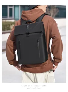 Outdoor shot of a black business backpack with fold-over top and leather buckle straps