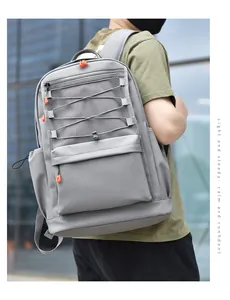 Detail of light grey casual backpack with orange accents and elastic bungee front cords