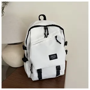 Detailed side view of white backpack with black zippers and logo on a wooden desk