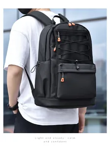 Close-up of black backpack featuring front mesh pocket and orange zipper accents