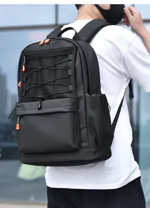 Outdoor detail of black nylon backpack featuring mesh front and orange zipper pulls