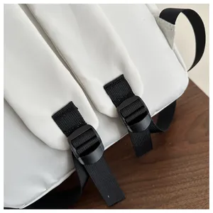 Detail view of white backpack straps with high-density nylon and black adjustable buckles