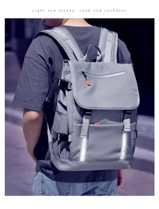 Detail of grey backpack featuring safety reflective strips and multiple zip compartments