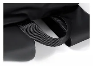 Detail of soft padded handle and waterproof black matte fabric on backpack