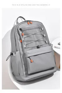 Detail of grey mesh front pocket with orange contrast zippers and elastic drawcord on backpack