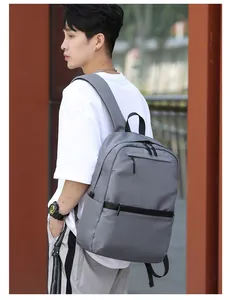Gray waterproof nylon business backpack shown on model in a professional outdoor setting