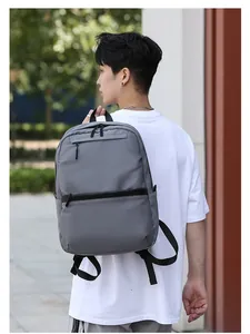 Outdoor view of a gray minimalist laptop backpack on a person showing side profile and size