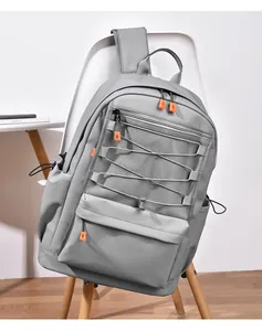 Close-up of light grey backpack with mesh pocket and orange zipper on a white chair