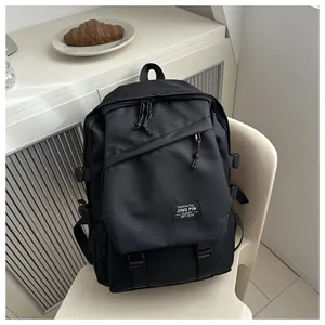 Detail of multi-pocket black backpack showing side buckles and fashion woven label