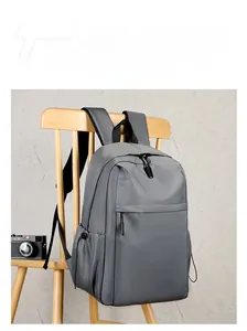 Gray travel backpack detail hanging on wood chair with retro camera prop