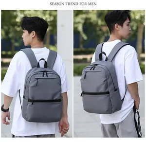 Detail view of a durable grey business backpack for men showing side profiles on a street