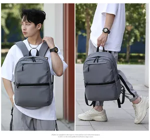 Gray large capacity business backpack with padded shoulder straps shown on a model