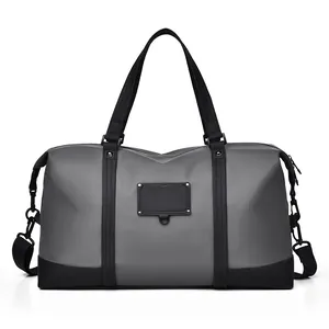 Waterproof grey duffel bag with black handles and detachable shoulder strap for travel