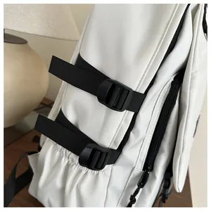 Detail view of white backpack side pocket with black adjustable strap and buckle