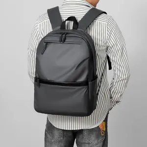 Minimalist dark grey water-resistant laptop backpack for men in a professional outdoor setting