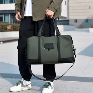 Olive green travel duffel bag with black leather trim and adjustable shoulder strap