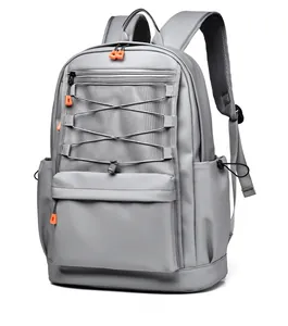 Macro shot of grey backpack showing orange bungee cords and breathable mesh front pocket