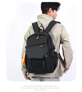 Détail d'un sac à dos pour ordinateur noir avec des touches orange et poches zippées
