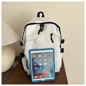 White nylon backpack with black zippers and side buckles next to a tablet for size reference