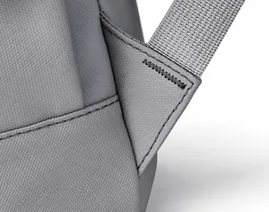 Detail of reinforced triangle stitching on grey backpack straps for enhanced durability